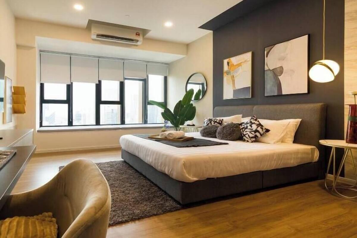 Une chambre à coucher moderne avec un lit, un bureau, une chaise et une grande fenêtre.