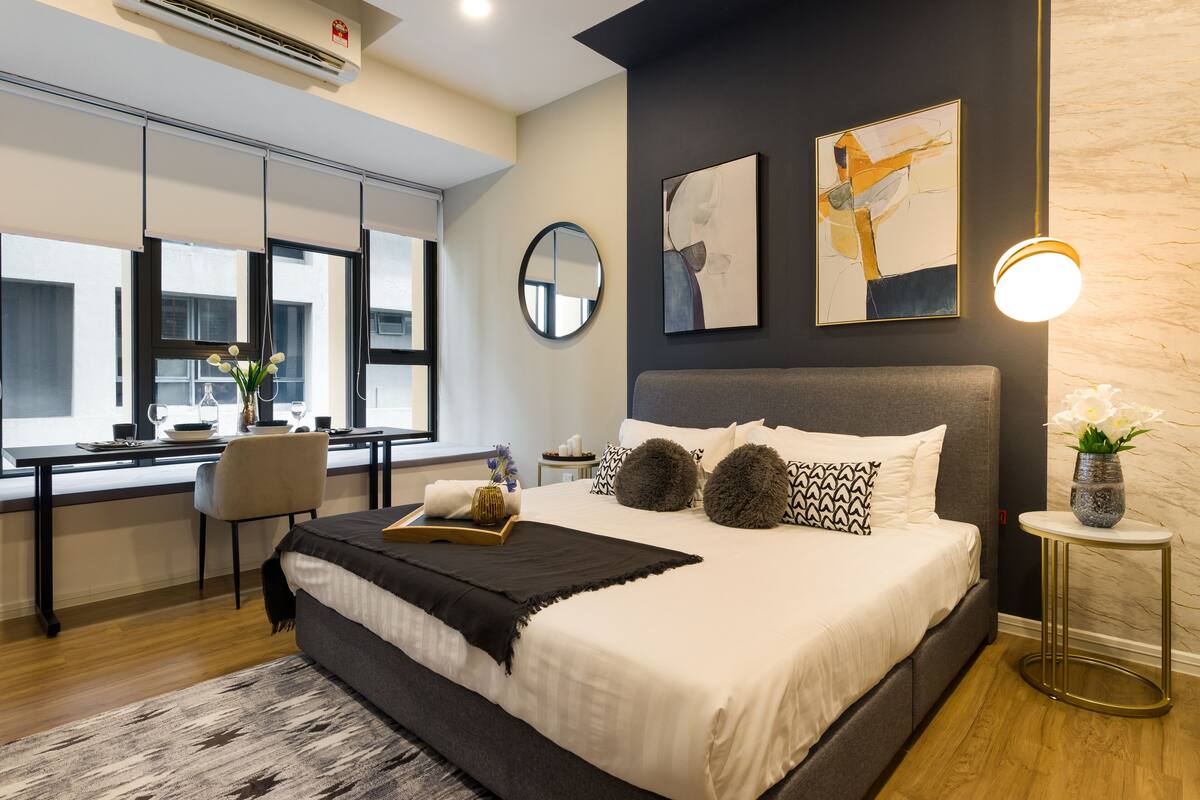 Une chambre à coucher moderne avec un grand lit, un bureau et une chaise.