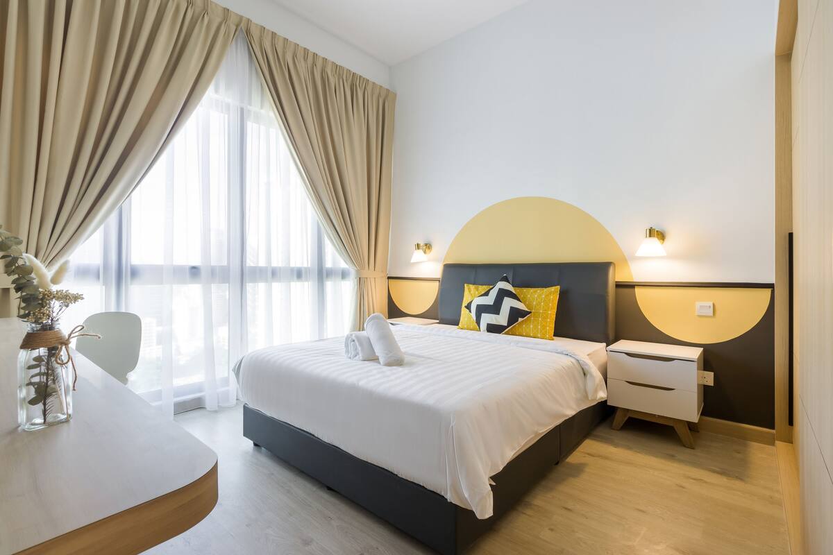 Een moderne hotelkamer met een groot bed, nachtkastjes en uitzicht op de stad.