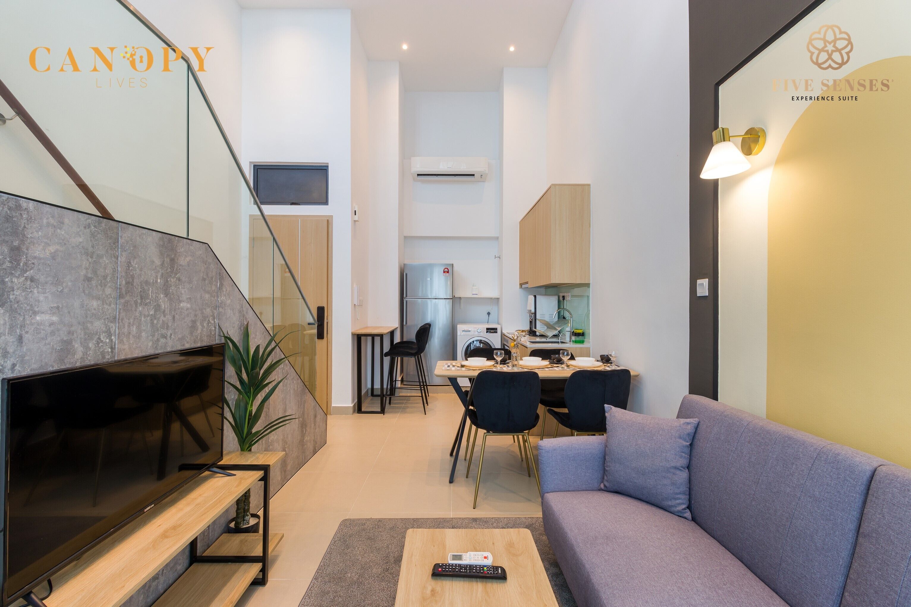Una sala de estar moderna con una televisión de pantalla plana, un sofá y una mesa de centro.