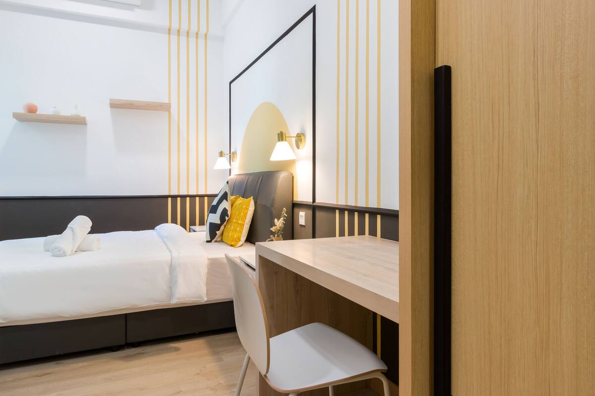 Een hotelkamer met twee bedden, een bureau en een spiegel.