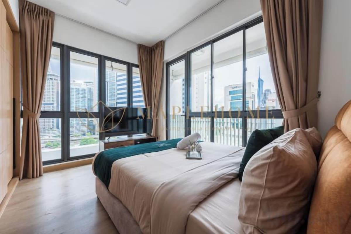 Una camera d'albergo con un letto grande, una televisione e un balcone vista città.