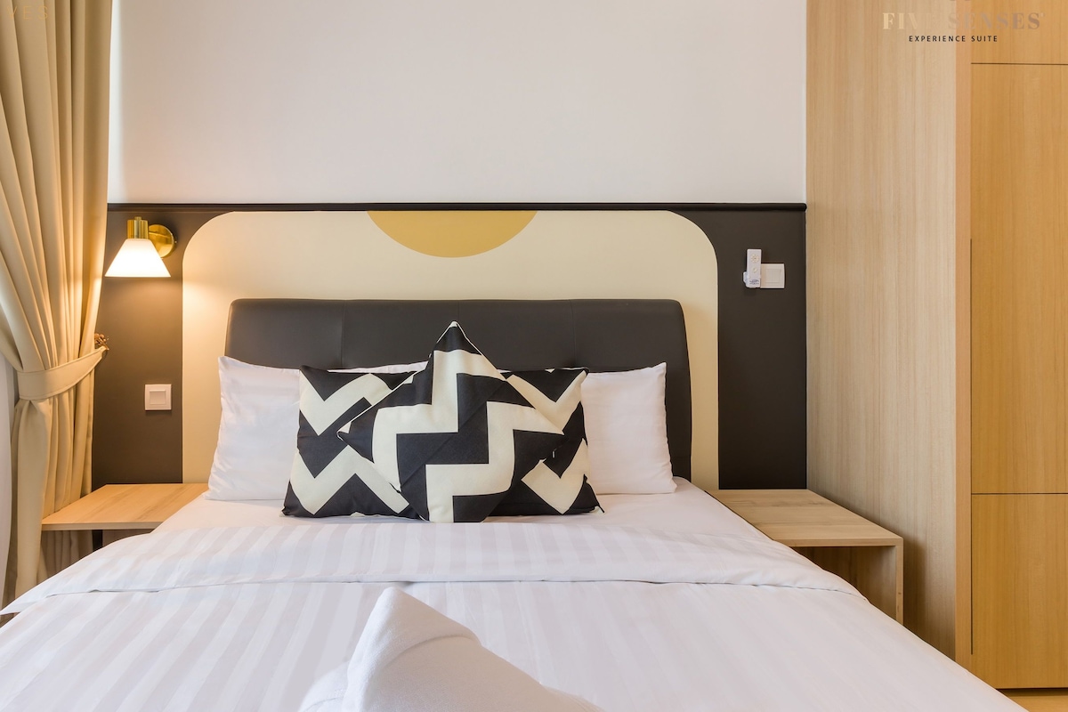 A hotel room with a bed, a nightstand, a lamp, and a wardrobe.