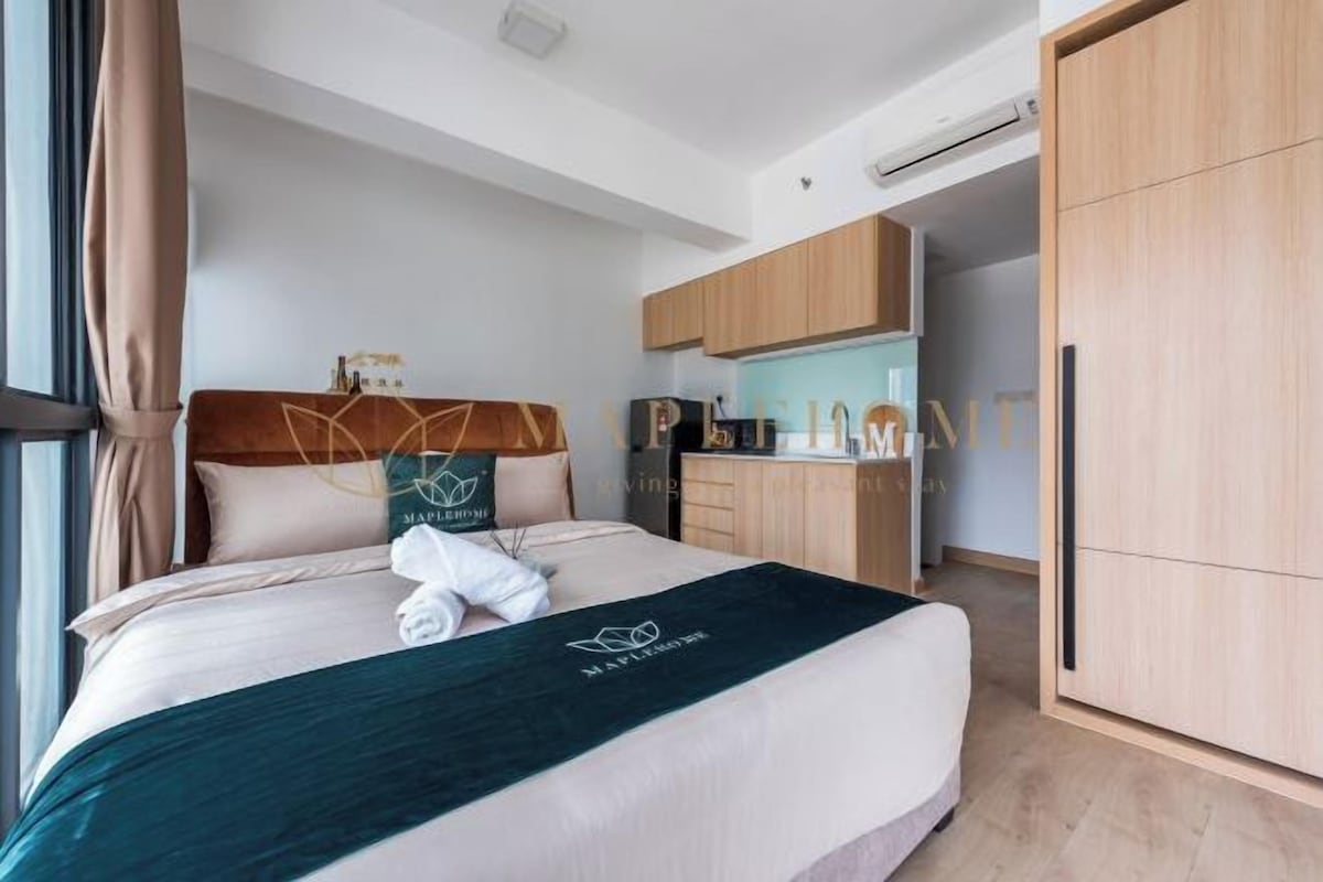 Una habitación de hotel con una cama, un escritorio y un armario.