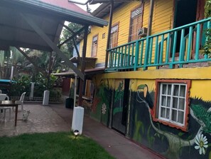 A colorful building with a mural, a balcony, and a covered outdoor area.