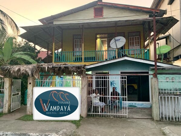 A two-story building with a sign for Vampaya Hostel & Hotel.