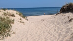 A sandy beach with dunes and a clear blue sky. - Family Friendly Lake Front New Build - 5bdrm + Hot Tub (Stevensville)