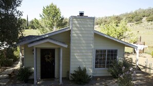 A small, single-story house with a gabled roof, a front door, and a window. - Private Cottage “Wild Rose” (Julian)