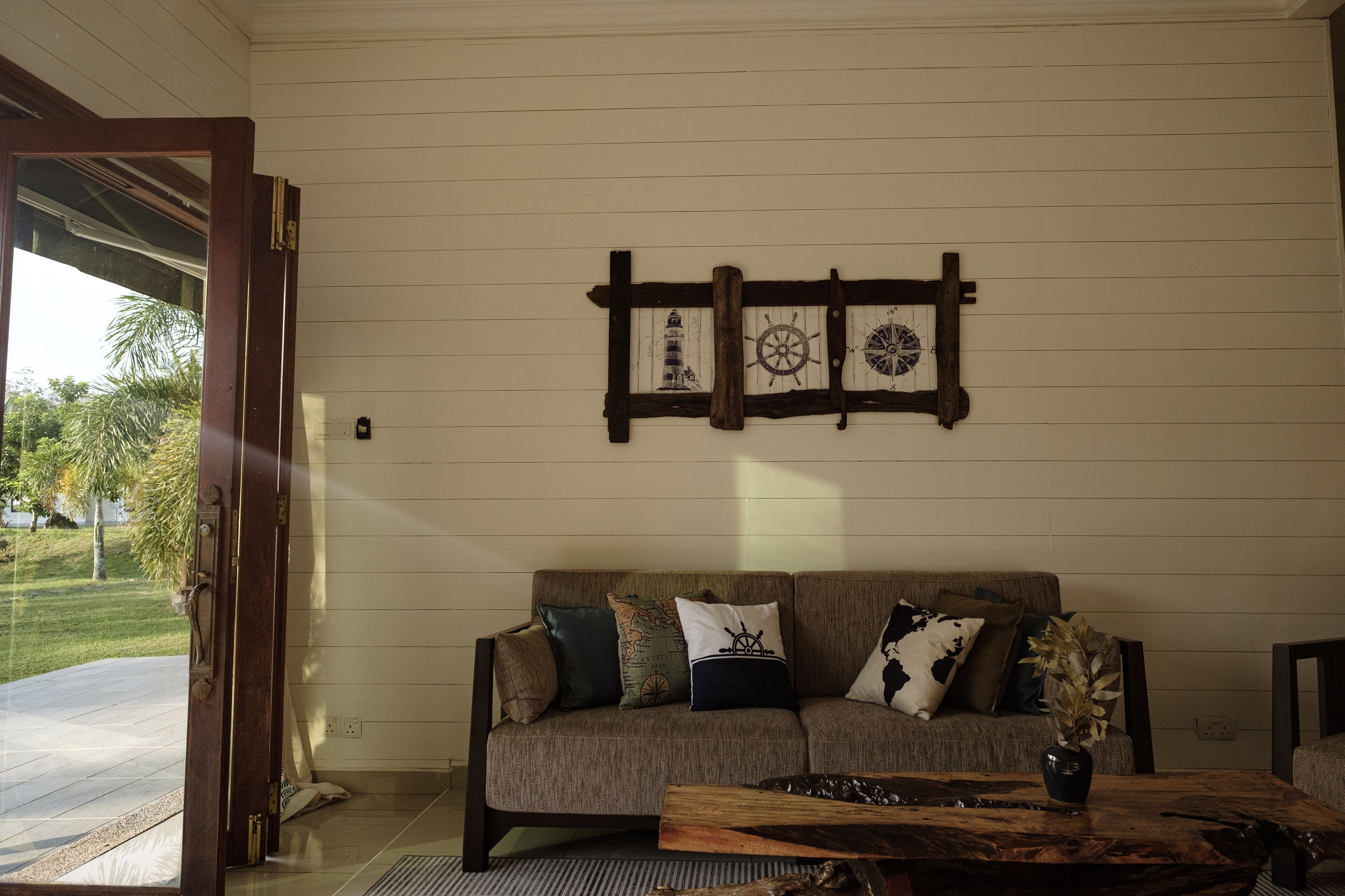 A living room with a sofa, a coffee table, and a wall-mounted decoration.
