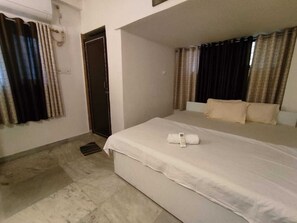 Una habitación de hotel con una cama, una puerta y cortinas.