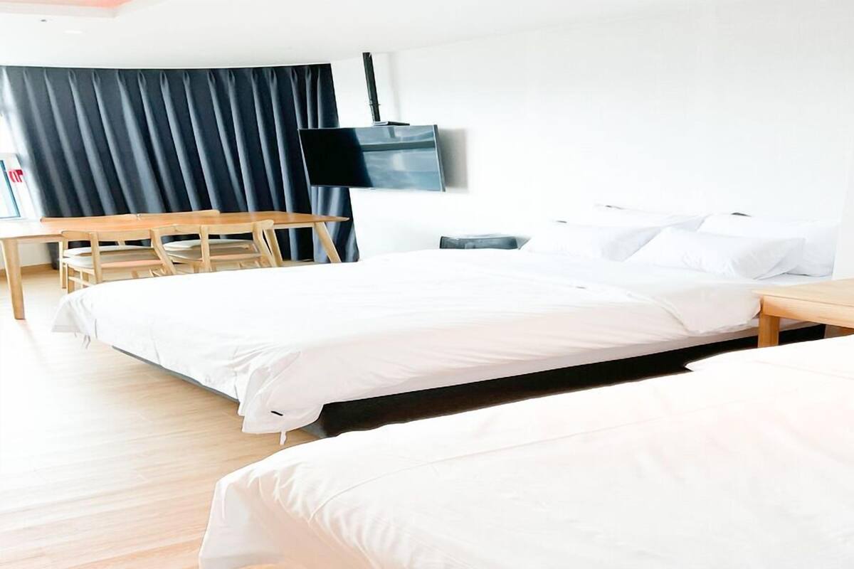 A hotel room with a bed, a desk, and a chair.