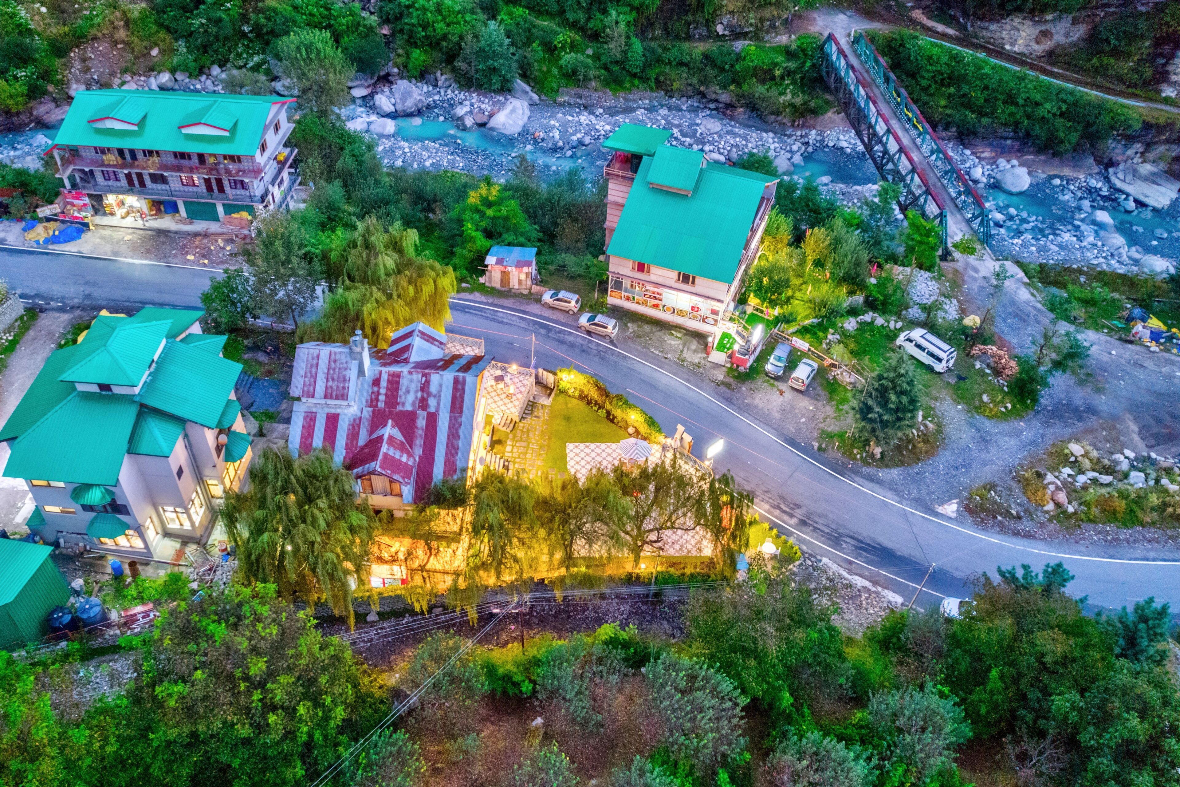 An aerial view of a residential area with multiple buildings, a bridge, and a river.