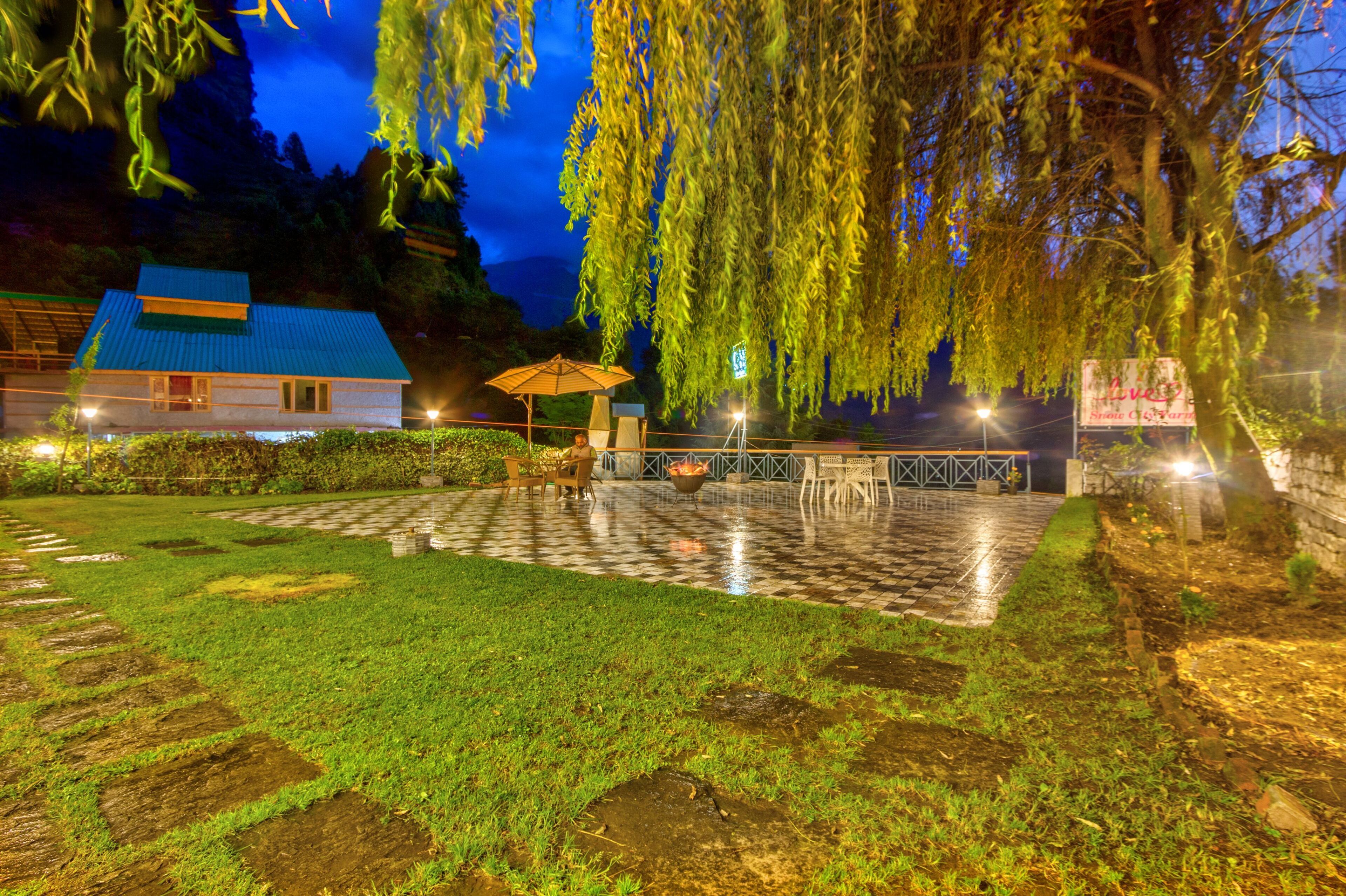 A courtyard with a checkered floor, a gazebo, and a building with a blue roof.