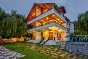 A two-story house with a balcony, stone steps, and a garden. - Solang Cottage By Snow City Farm (Manali)