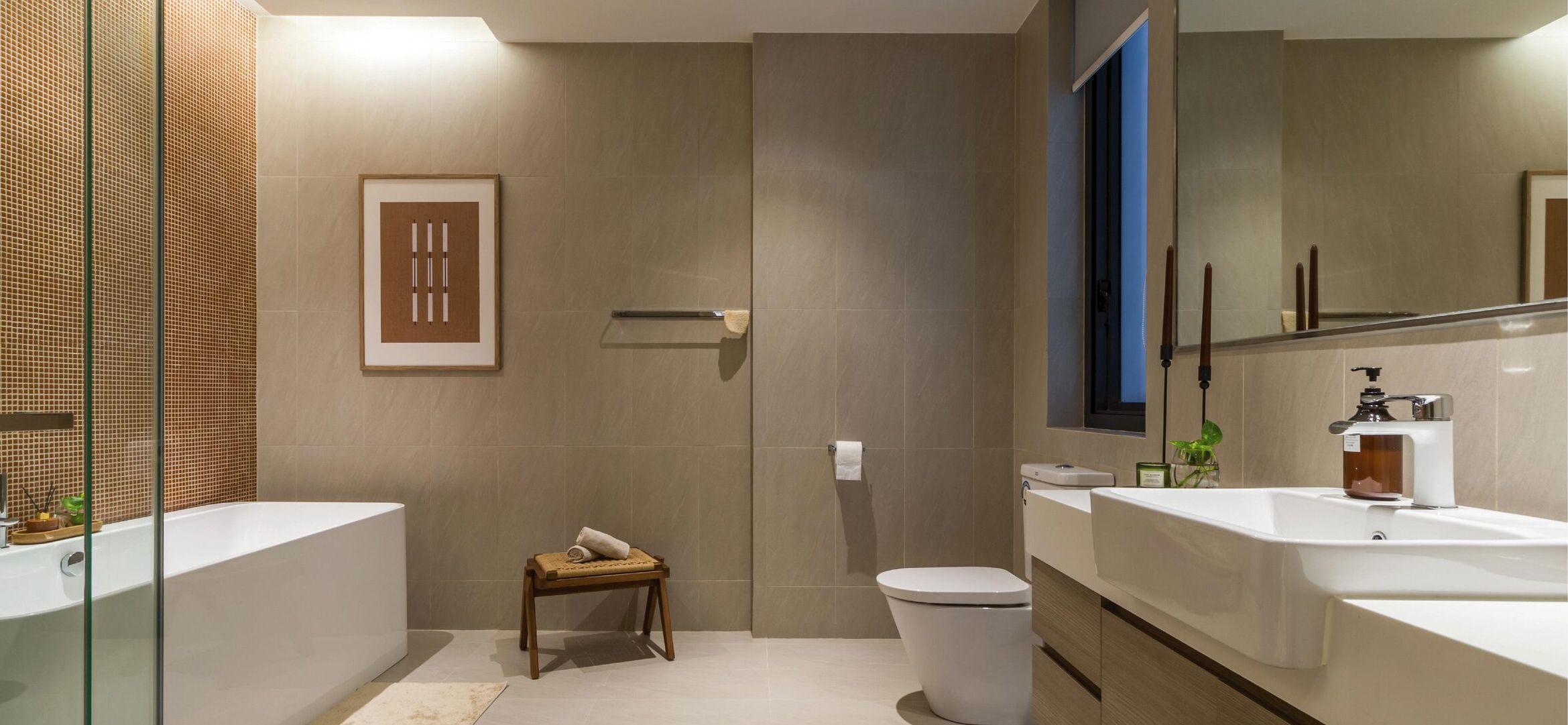 Un baño moderno con una bañera grande, dos lavamanos, un inodoro y una zona de ducha.