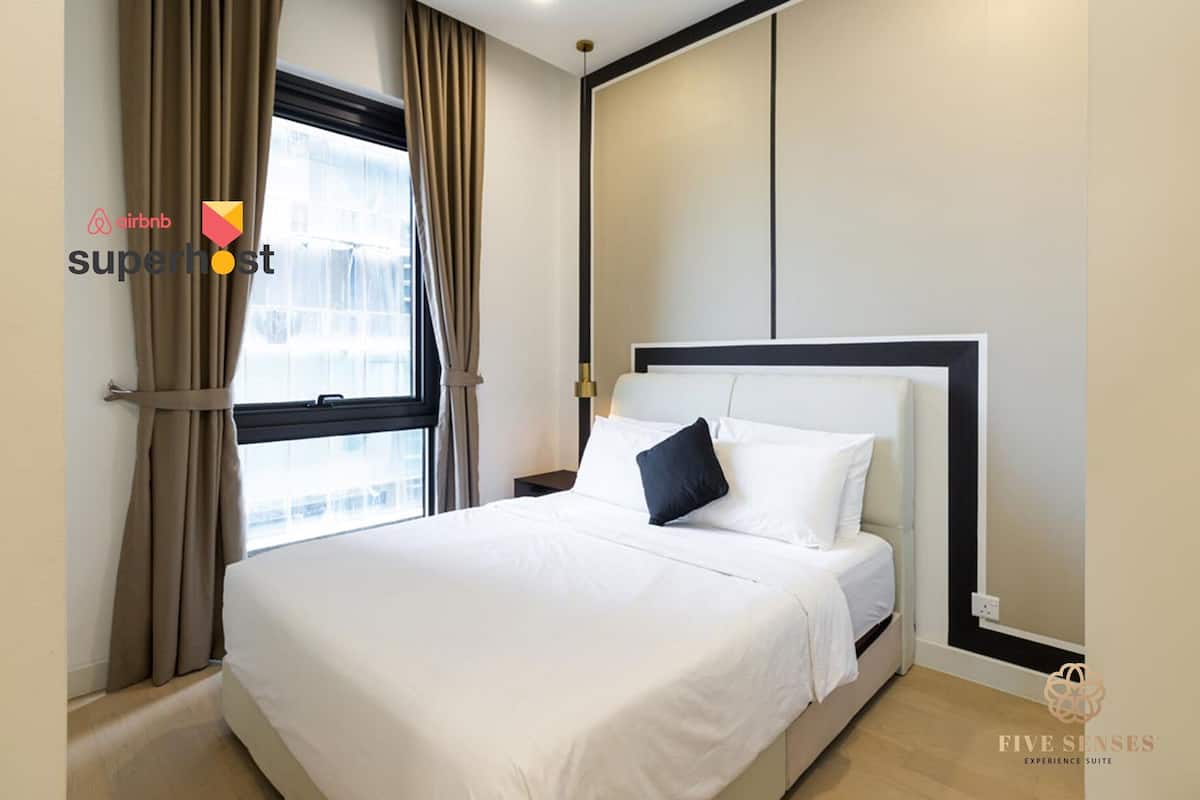 Quarto de hotel com cama, cortinas, janela e painel de parede.