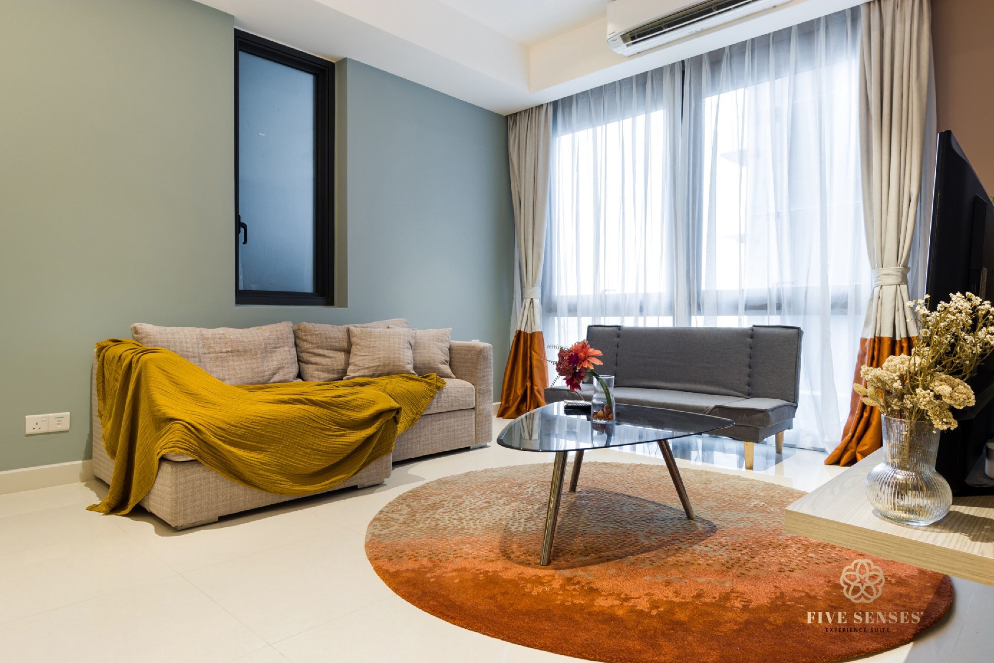 A modern living room with a sofa, a coffee table, and a TV.