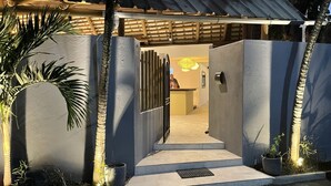 Una entrada con portón y un camino de hormigón que lleva a un edificio.