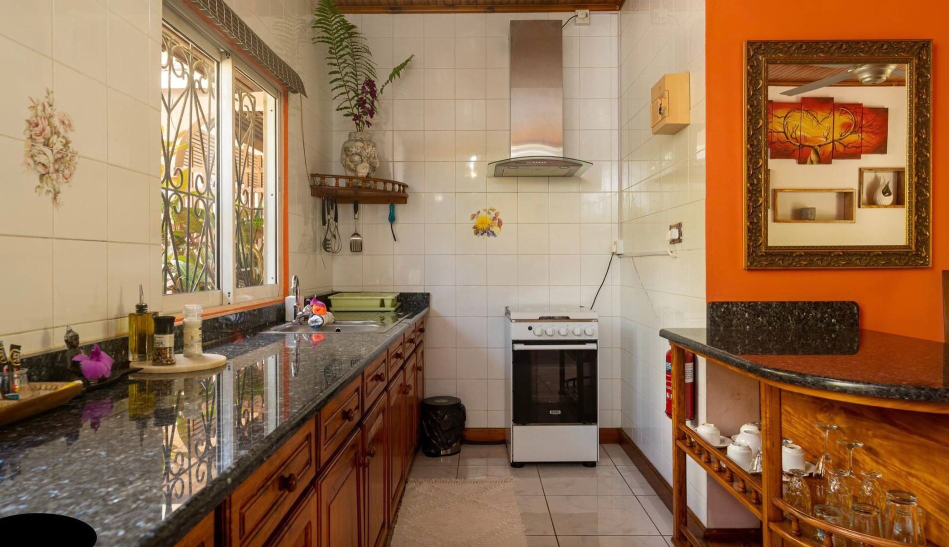 Une cuisine équipée d’une cuisinière, d’un évier et de placards.