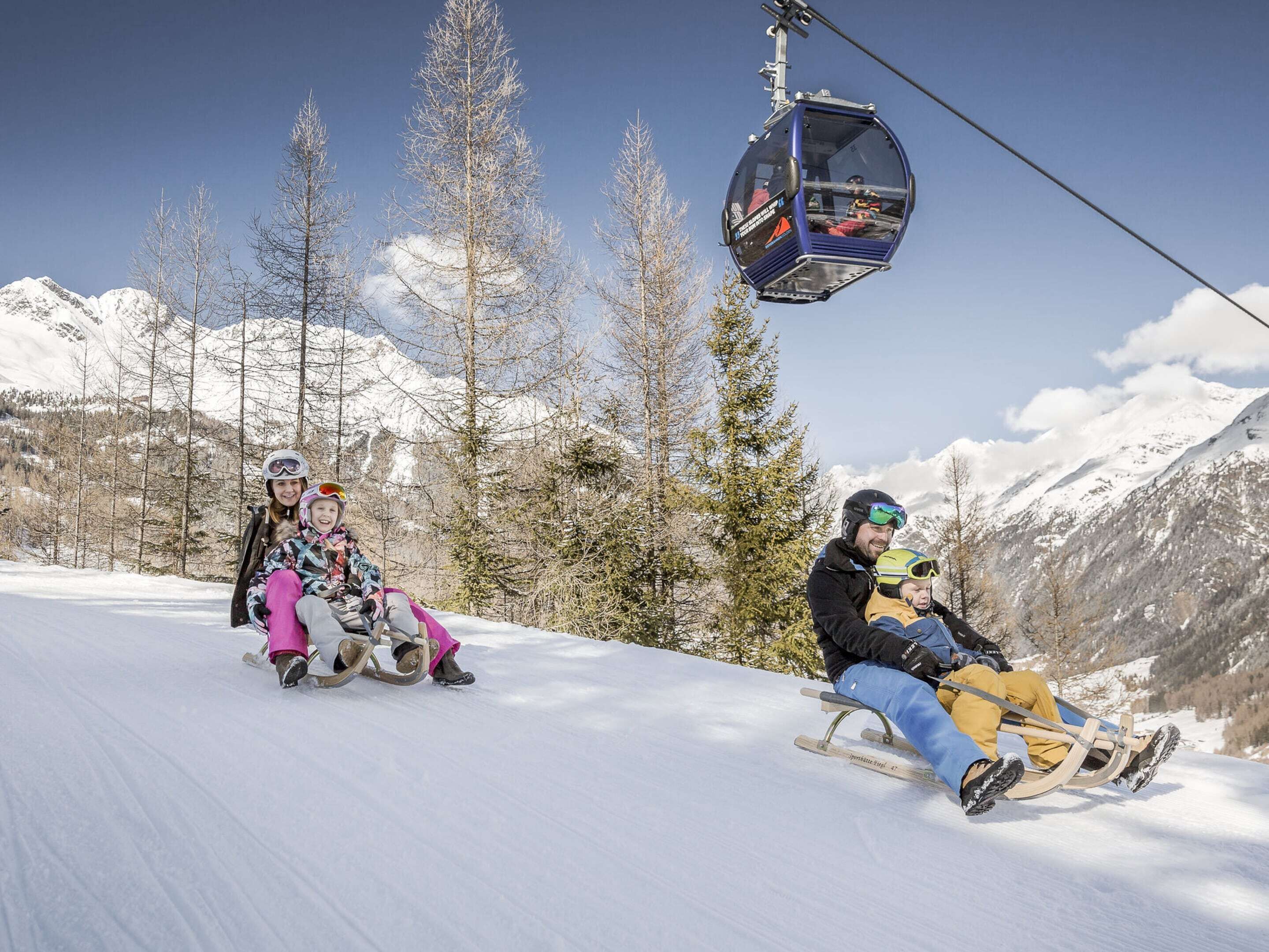 A snowy mountain slope with a ski lift and skiers.