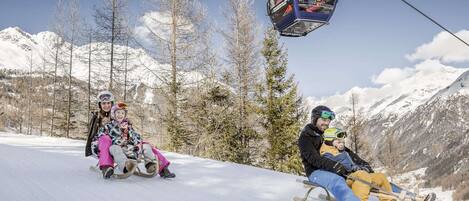 A snowy mountain slope with a ski lift and skiers.