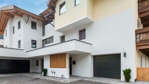 A modern multi-story residential building with a flat roof, large windows, and a covered driveway. - Apartment in Umhausen With Garden and Barbecue (Umhausen)