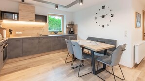 A modern kitchen with a built-in microwave, grey cabinets, a wooden countertop, and a window with a view of greenery. - Apartment in Umhausen With Garden and Barbecue (Umhausen)