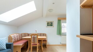 A cozy room with a loft bed, a dining table with chairs, a sofa, and a window with a view. - Cosy Apartment in Ladis With Balcony and View (Ladis)