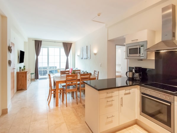 A modern kitchen with a central island, built-in microwave, and stainless steel appliances. - Apartment Zwieselstein Near Ski Slopes (Soelden)