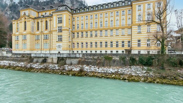 A large, yellow building with multiple windows and a stone wall in front. - Holiday Home Feldkirch Panoramic Views (Feldkirch)