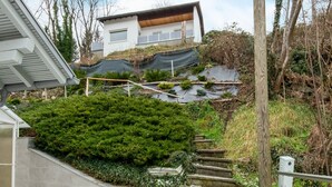A residential property with a staircase leading to a house, surrounded by greenery and trees. - Holiday Home Feldkirch Panoramic Views (Feldkirch)