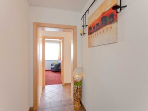 Enter a cozy room with a plush red carpet, a comfortable chair by the window, and a beautiful elephant painting on the wall.