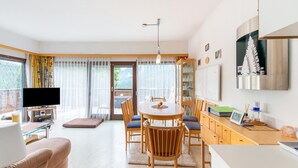 A modern living room with a TV, sofa, and dining area. - Apartment Tauplitz Near Ski Lift & Slopes (Bad Mitterndorf)