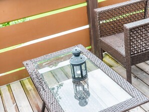 Relax on the deck with a lantern-lit table and a comfortable wicker chair.
