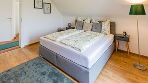 Una camera da letto con un letto, un comodino, una lampada e una porta.