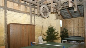 A rustic room with two ping pong tables, a wooden cabinet, and a small Christmas tree. - Apartment in Bleiburg Near the ski Resort (Feistritz ob Bleiburg)