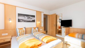 A modern hotel room with a large bed, a TV, a desk, and a mirror. - Inviting Holiday Apartment in Ladis With Balcony (Ladis)