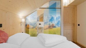 A bedroom with a bed, a wooden ceiling, a bathroom with a sink, and a door. - Chalet in Hohentauern Near Ski Lift (Hohentauern)