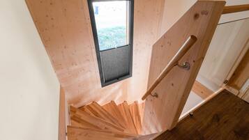 Eine Holztreppe mit einem kleinen Fenster am oberen Ende, einer Handlauf und einem Holzboden.