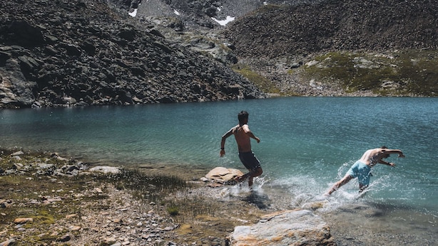 A rocky shoreline with clear water and mountains in the background. - Apartment in Solden Near Ski Lift (Soelden)