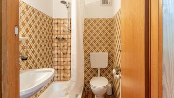 Un baño con ducha, inodoro y lavamanos.