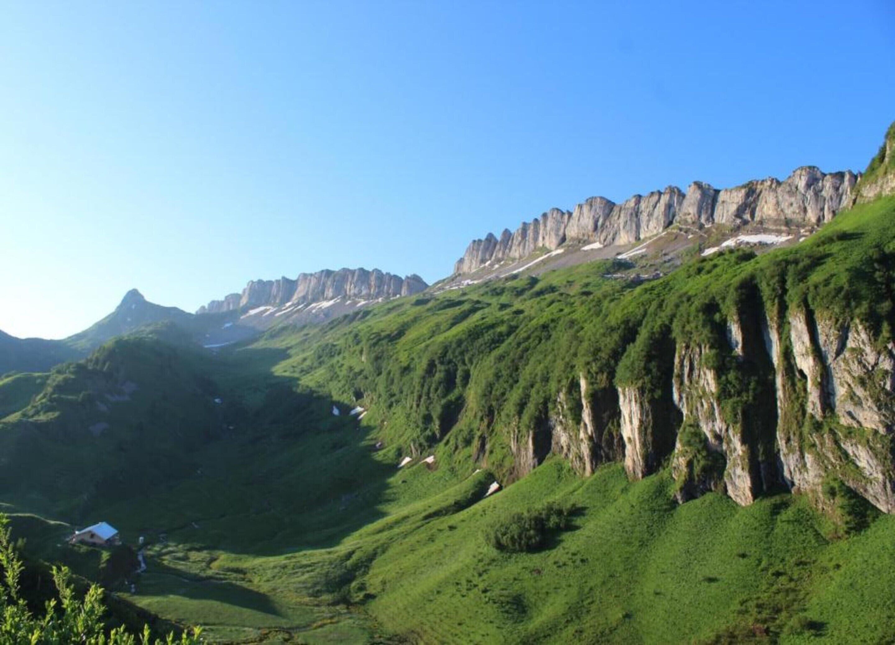 Een bergachtig landschap met rotsachtige kliffen en weelderige groene valleien.