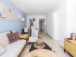 Ein modernes Wohnzimmer mit einer Couch, einem Couchtisch und einem Essbereich mit Stühlen und einem Tisch.