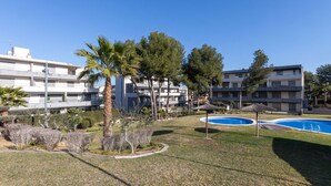 A residential area with two swimming pools, palm trees, and apartment buildings. - Tramontana by Interhome (Salou)