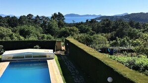 Una piscina con vista despejada al mar y colinas al fondo.