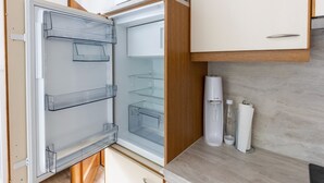 Ett modernt kök med ett inbyggt kylskåp, träskåp och en bänkskiva i marmor.