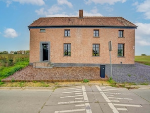A two-story brick building with a flat roof, numbered 38, featuring a front door, windows, and a small porch area. - Lush Holiday Home in Vlaanderen With Private Pool (Lennik)