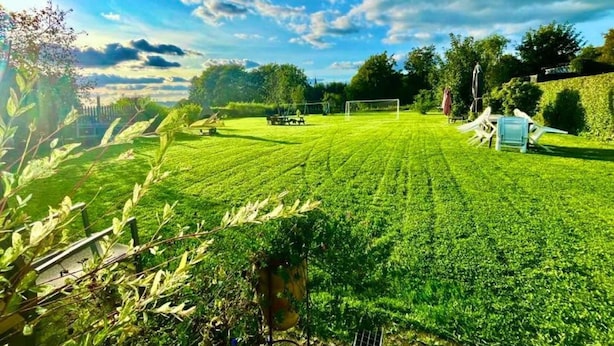 A well-maintained lawn with a goalpost, surrounded by trees and a clear sky. - Holiday Apartment in Beautiful Hunningen (Buellingen)