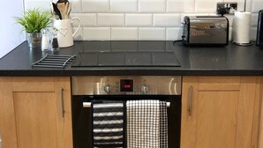 Eine moderne Küche mit schwarzem Arbeitsplatten, Edelstahlgeräten und einer weißen Küchenwand.