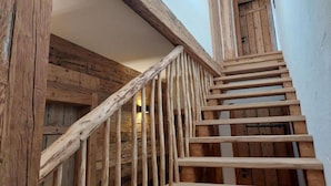 A wooden staircase with a rustic design, leading to a door at the top.